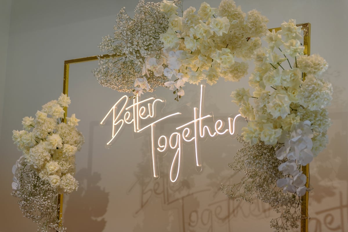 Wedding reception photo wall decorated with flowers and greenery