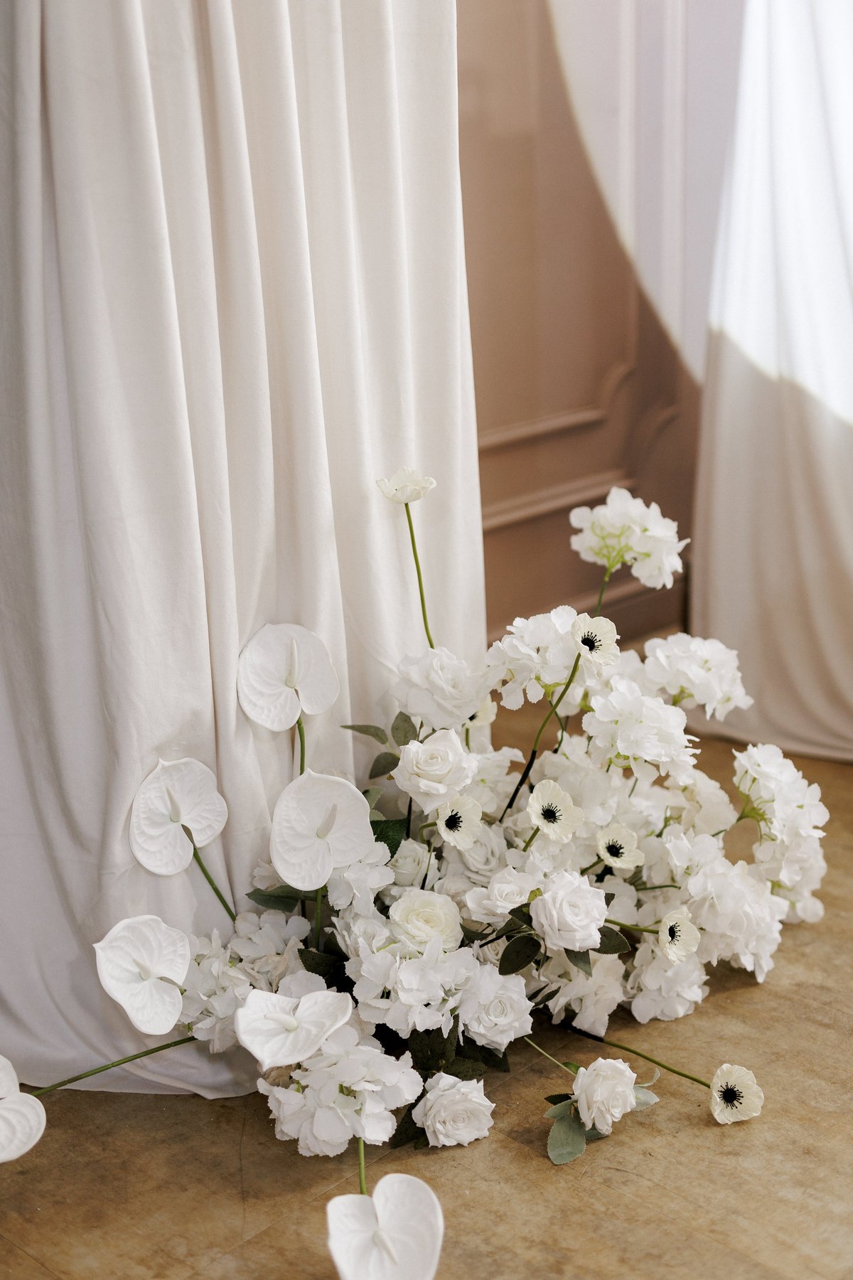 Wedding party photo booth wall zone decorated with white flowers